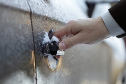 Befagyott autóajtó kilincs télen, jéggel borított ajtón