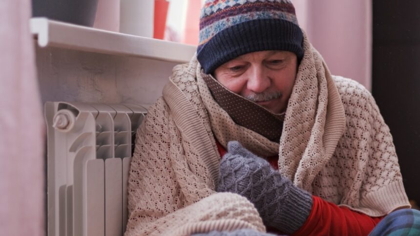 Fázó férfi a radiátor mellett