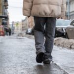 Egy férfi sétál a jeges járdán