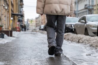 Egy férfi sétál a jeges járdán