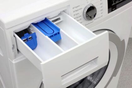 mosógép nyitott mosószer-adagoló fiókja három külön rekesszel